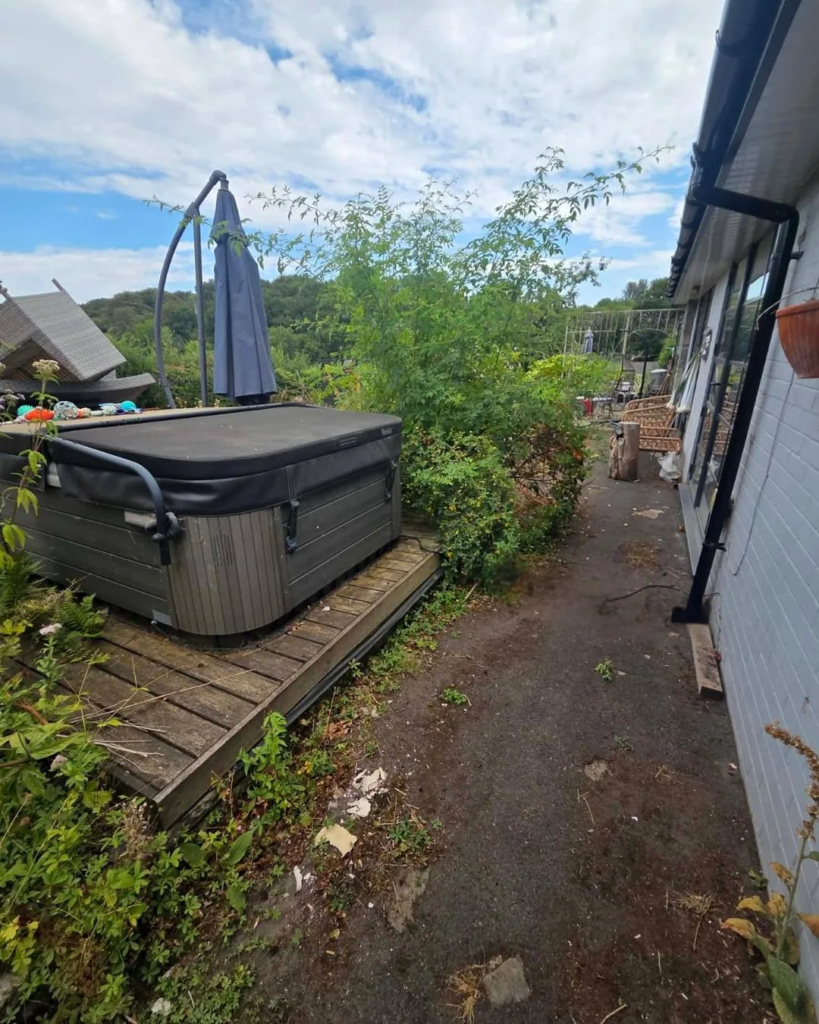 Before: muddy side path with an old timber platform under the hot tub