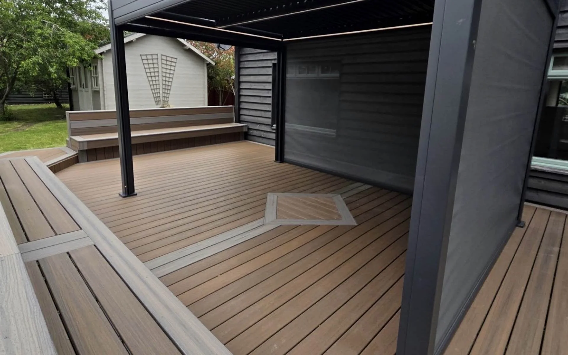 Trex composite deck with louvred pergola, built-in bench and feature inlay