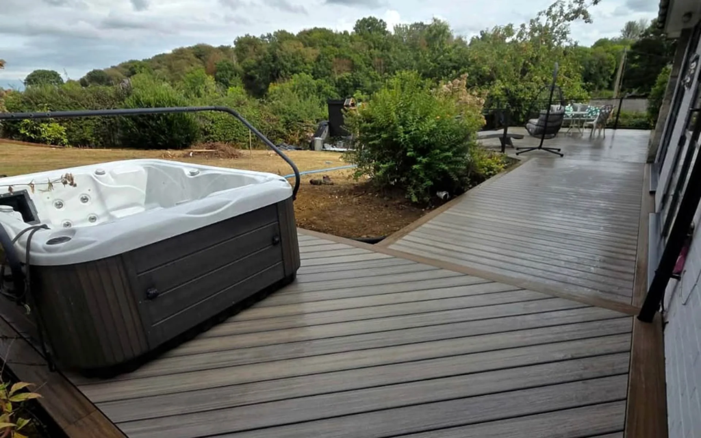 Wraparound Trex composite deck with a hot tub, replacing old timber decking in South Wales