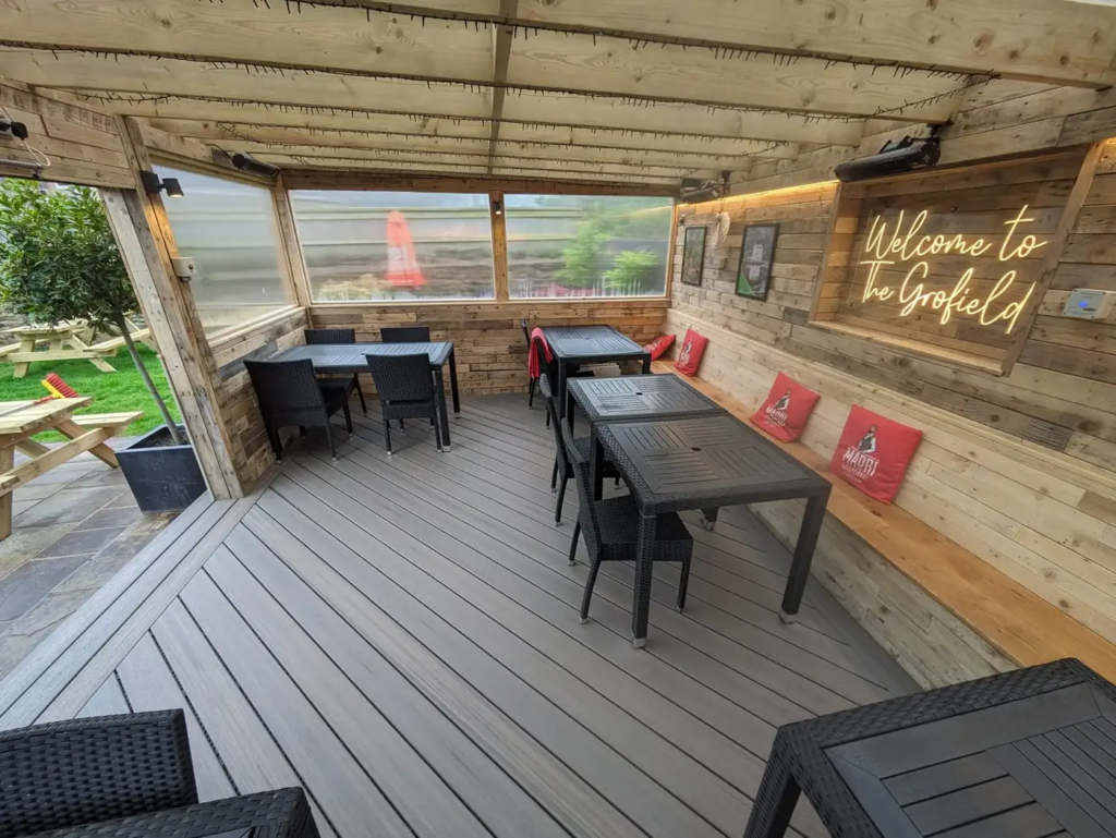 Tables and bench seating on the Trex deck at The Grofield pub, Abergavenny