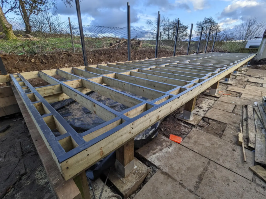Composite deck subframe built on a slope with posts and footings