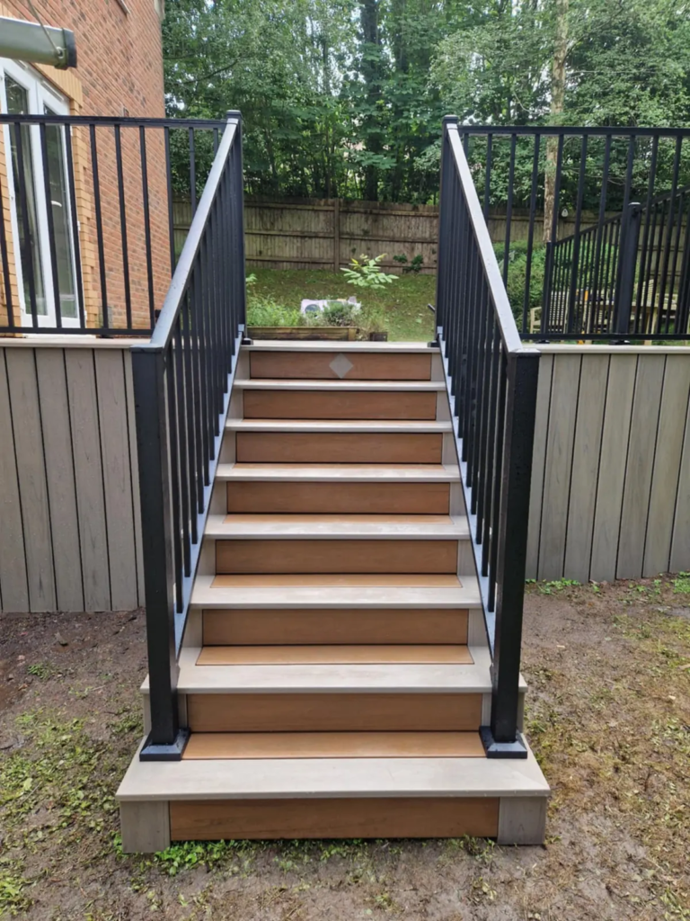 Composite steps with black metal railings up to a raised deck