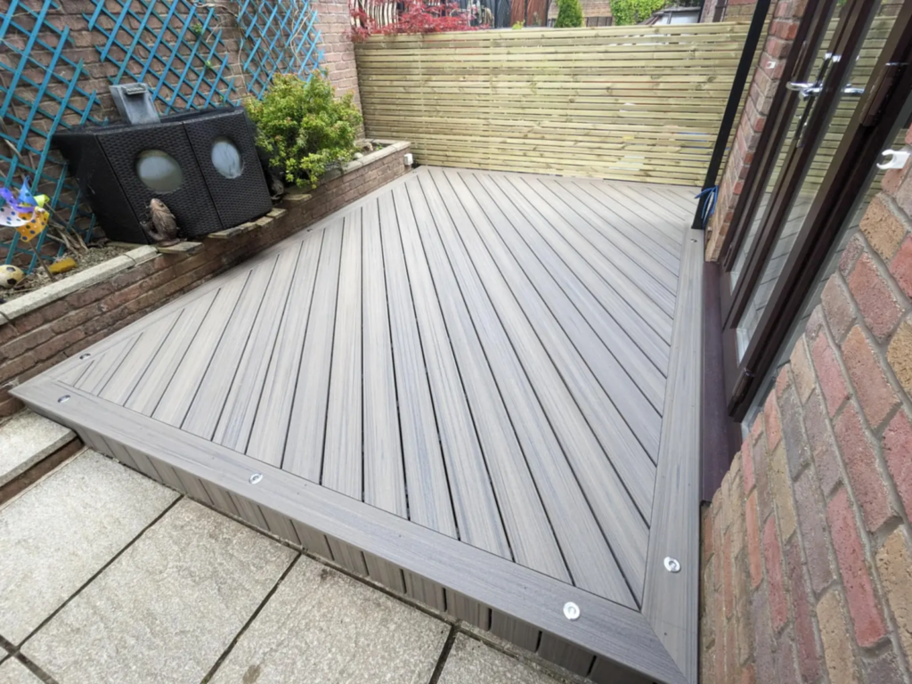 Composite deck by the patio doors of a terraced house, finished in Trex