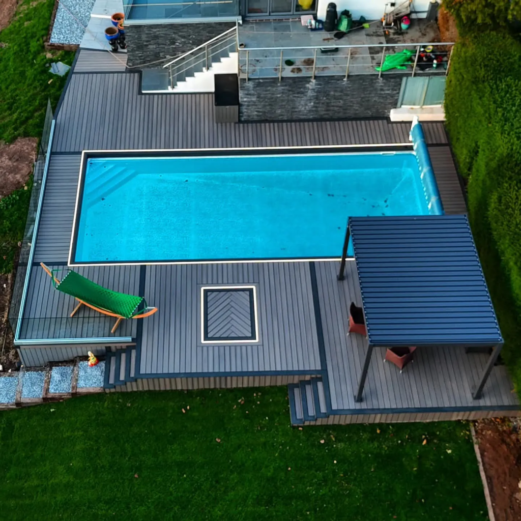 Composite pool deck in Raglan with a herringbone inlay, lighting, glass edge and pergola, seen from above