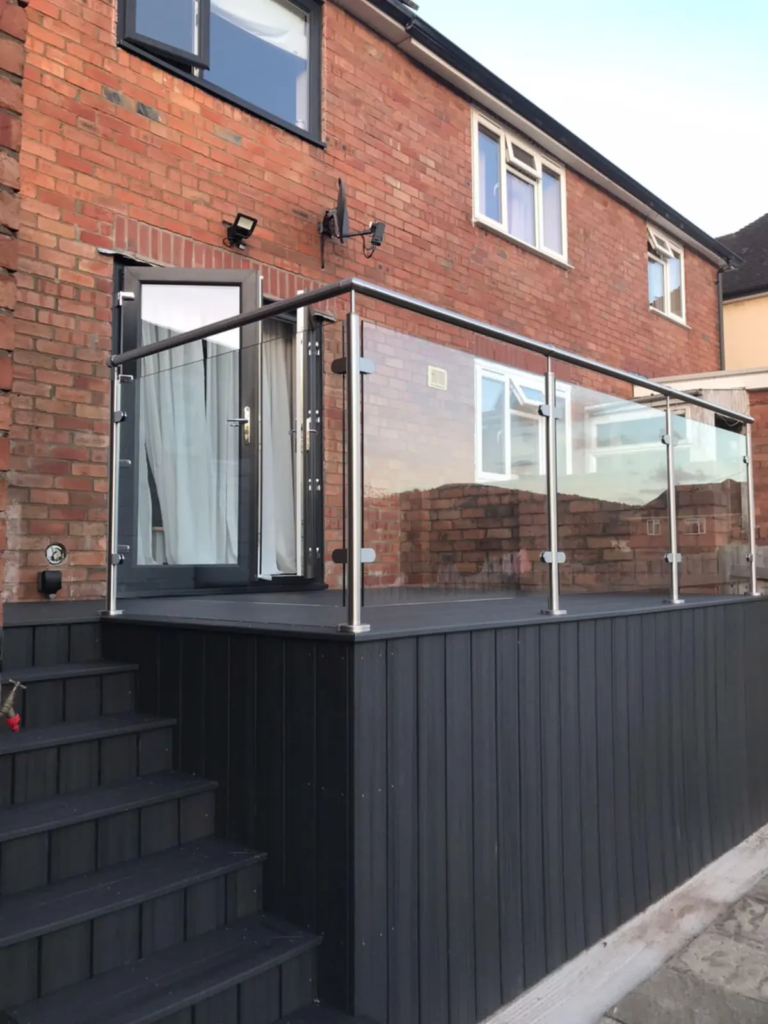 Raised composite deck with glass balustrade and steps, the kind of build that can need planning permission
