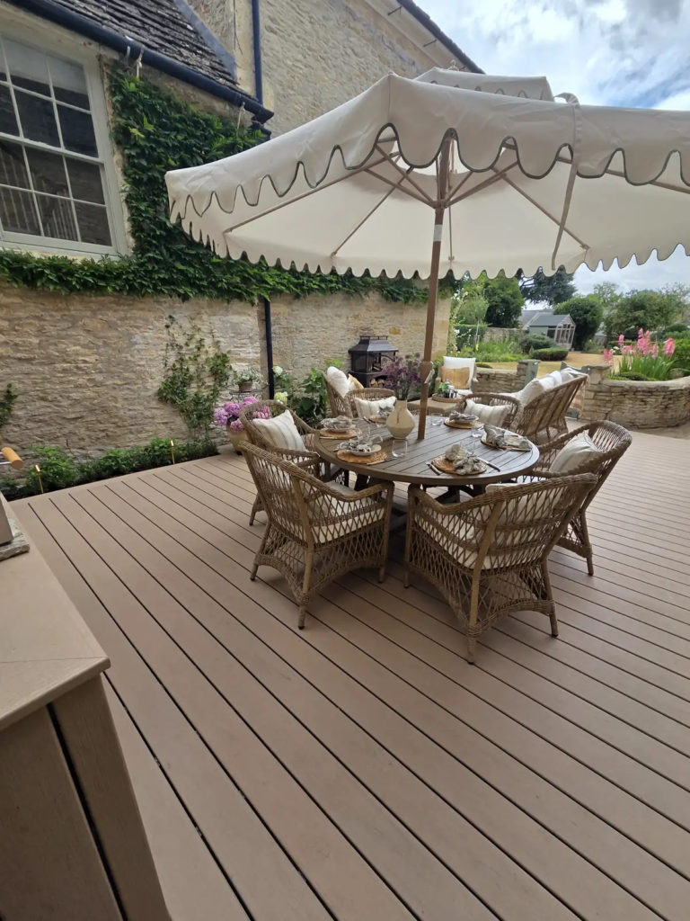 Dining area on the Trex deck under a parasol in a Cotswold courtyard