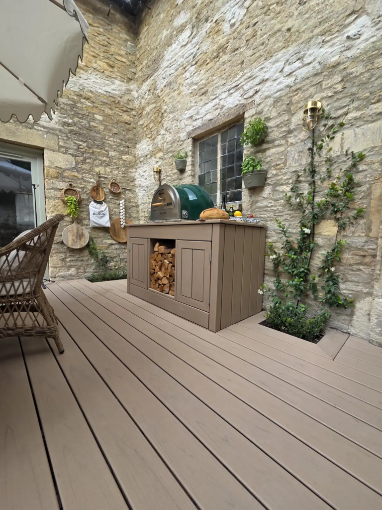 Trex outdoor kitchen with pizza oven against Cotswold stone