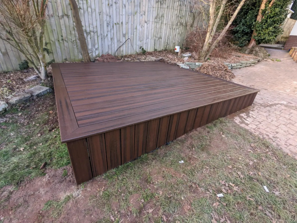 Small garden deck finished in dark Trex composite boards with fascia