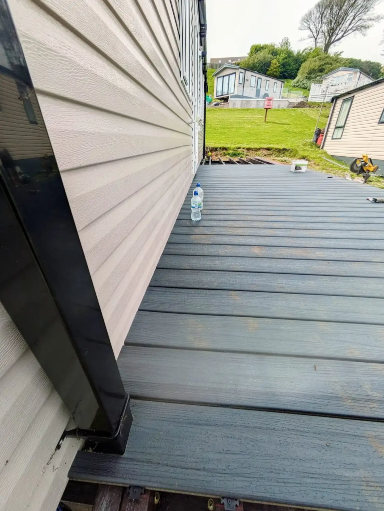 Trex boards being laid along a static caravan